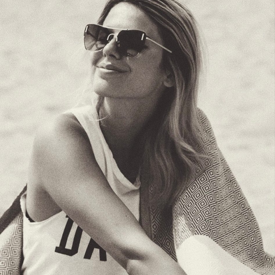 Influencerin Marina_lovesnyc sitzt im Sand und trägt eine Sonnenbrille von Sylvie Optics.